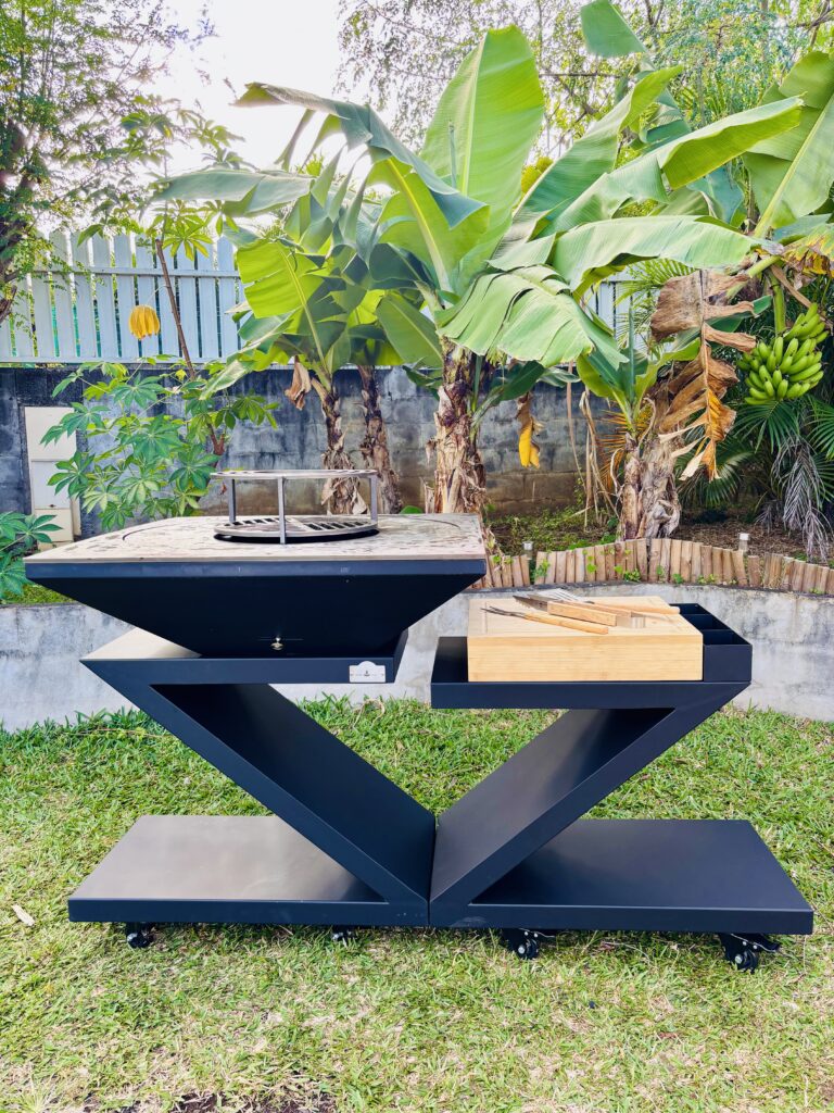 Brasero-plancha BRASE RUN Signature Z noir installé dans un jardin tropical à La Réunion